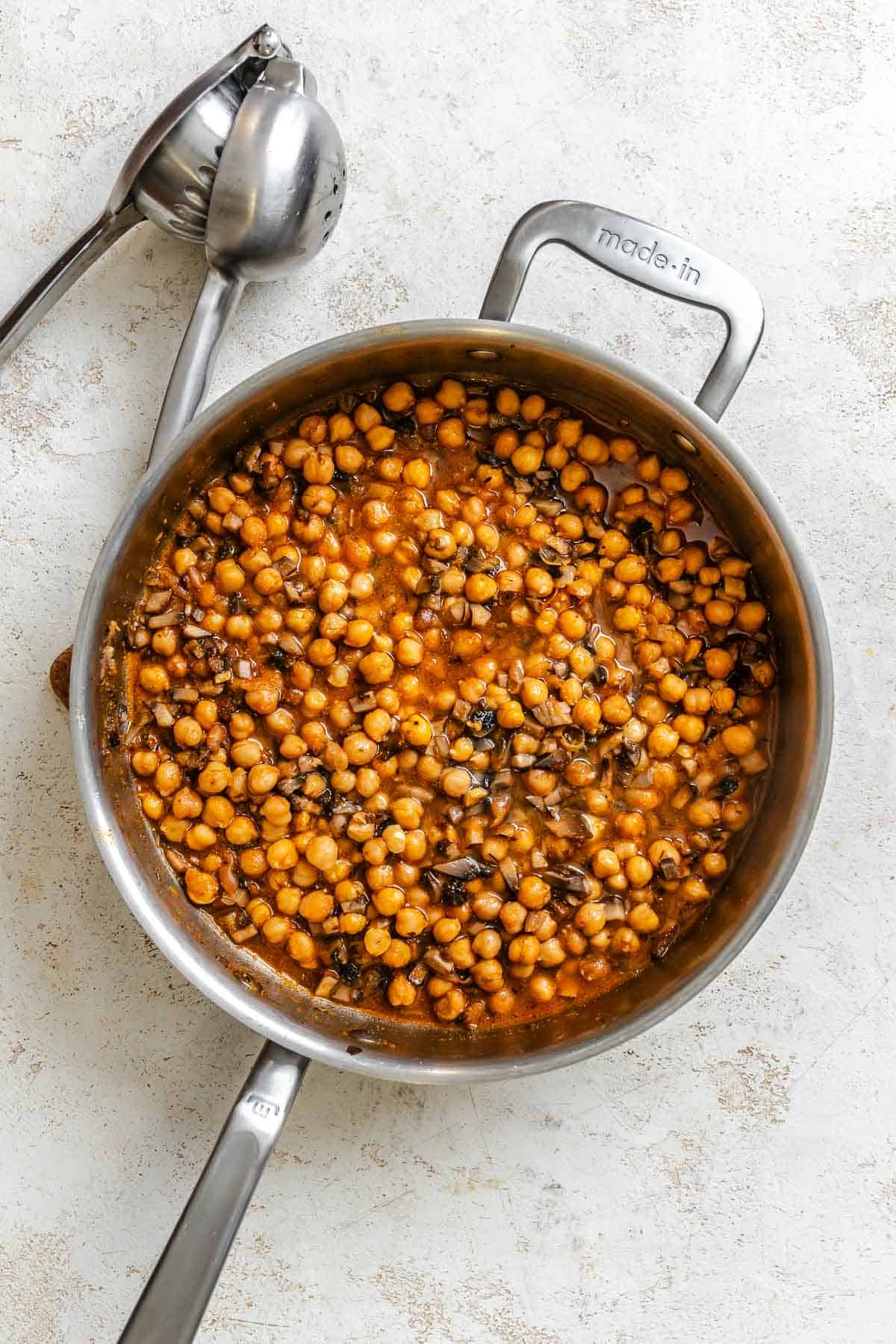 Process shot showing ingredients cooking in pan.