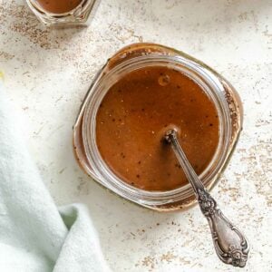 Completed Spinach Salad Dressing in a jar on a white surface.
