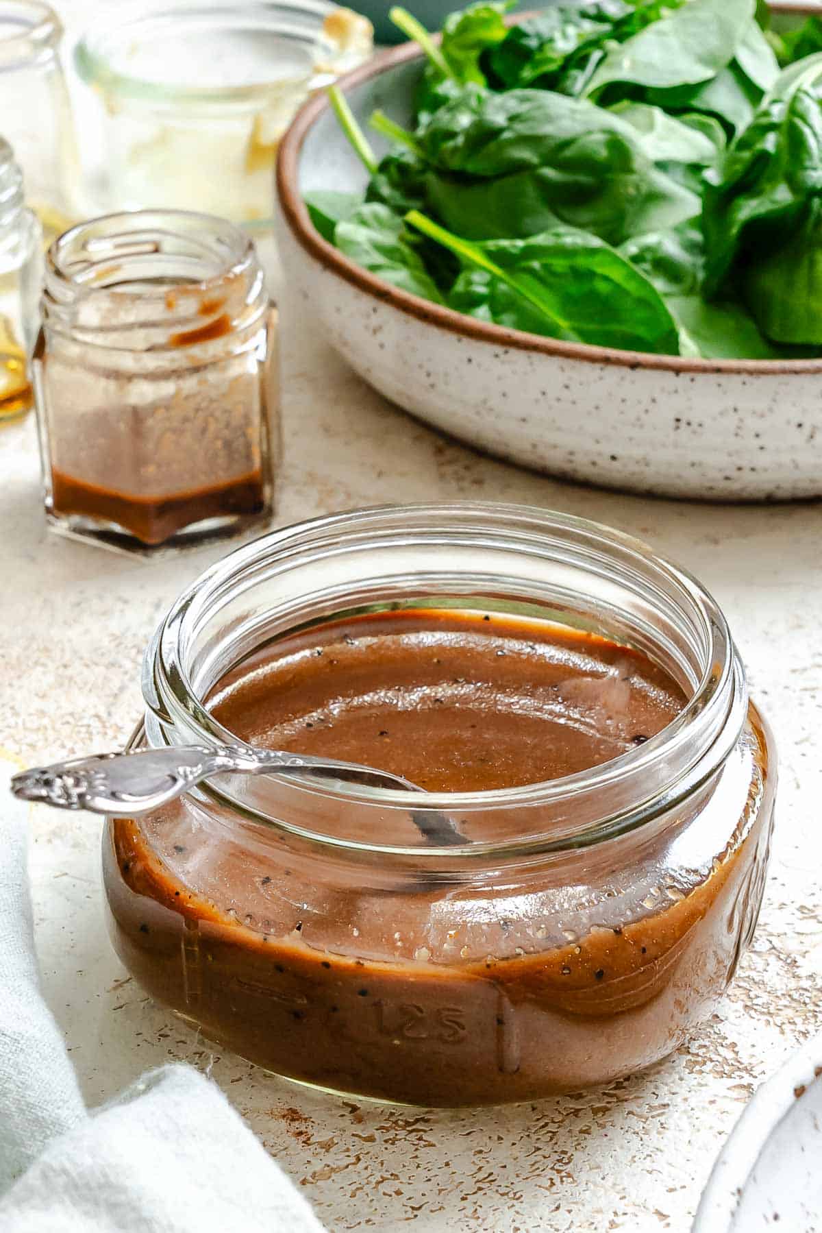 Completed Spinach Salad Dressing in a jar on a white surface.