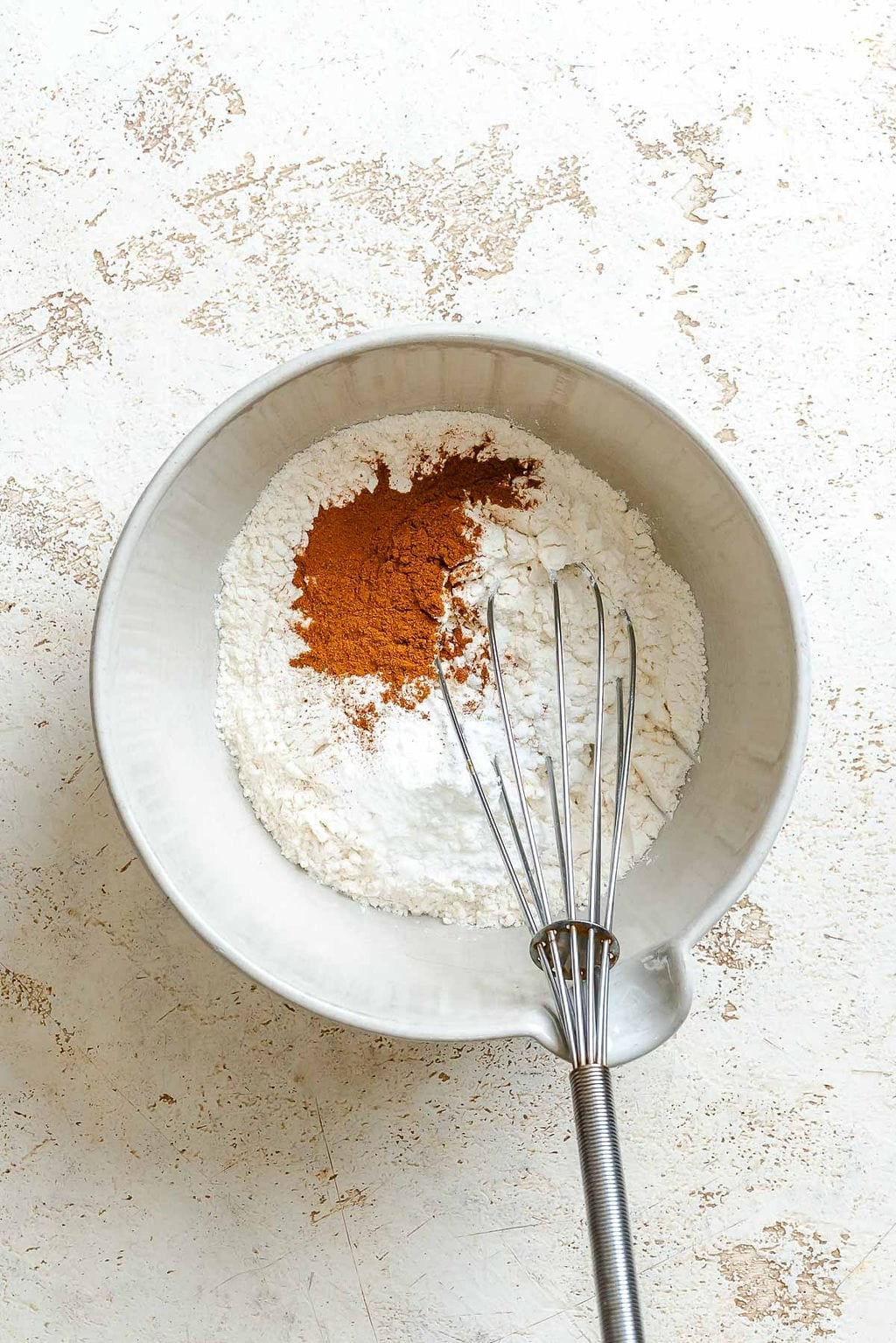 Process shot showing whisking ingredients in a bowl.