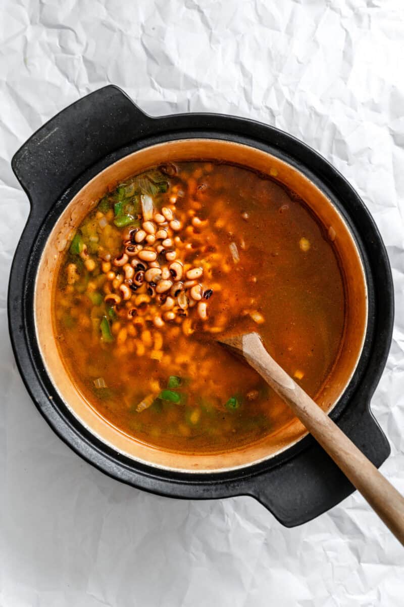 Process shot showing stirring soup in pot.