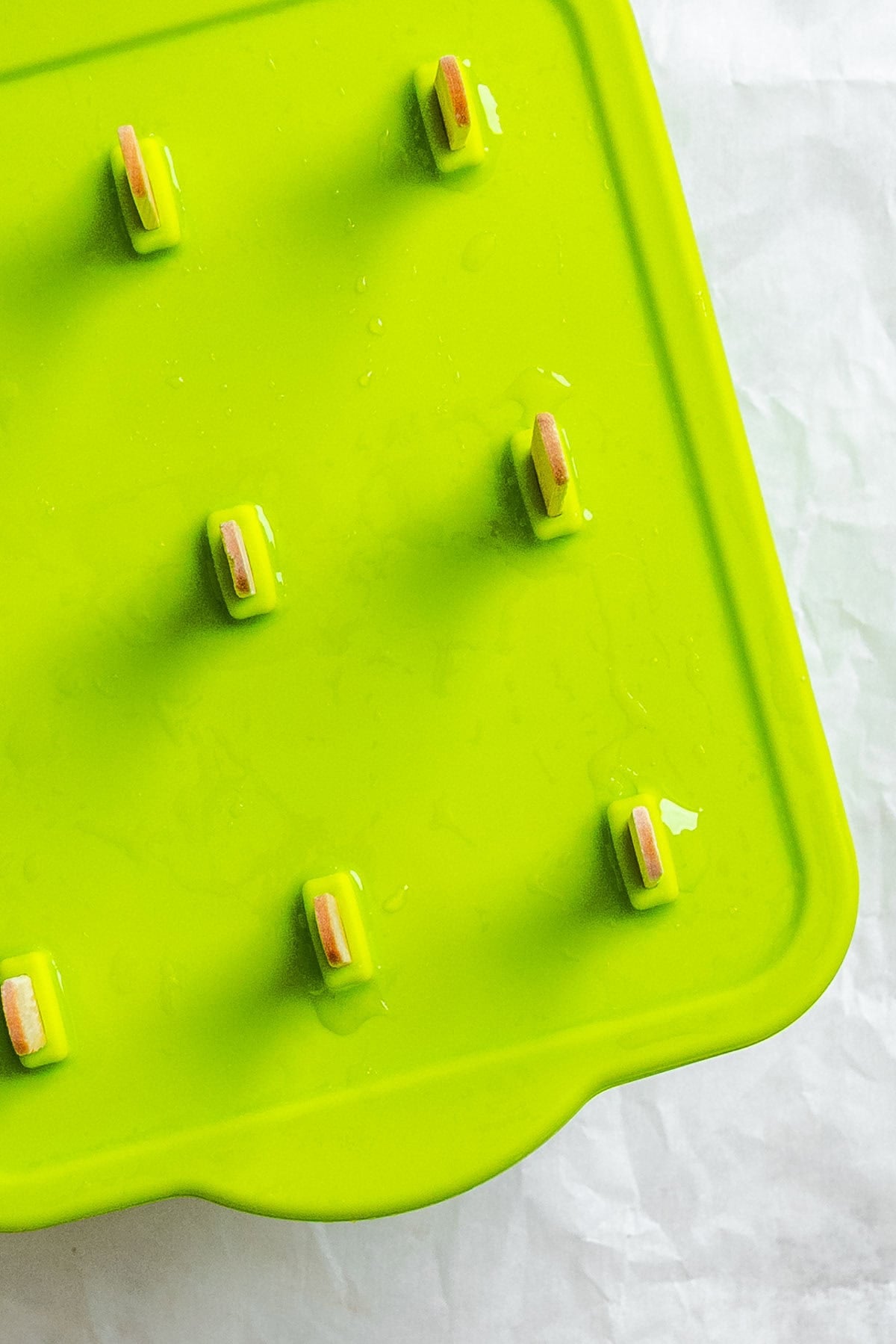Several completed Easy Lime Popsicles in popsicle mold.