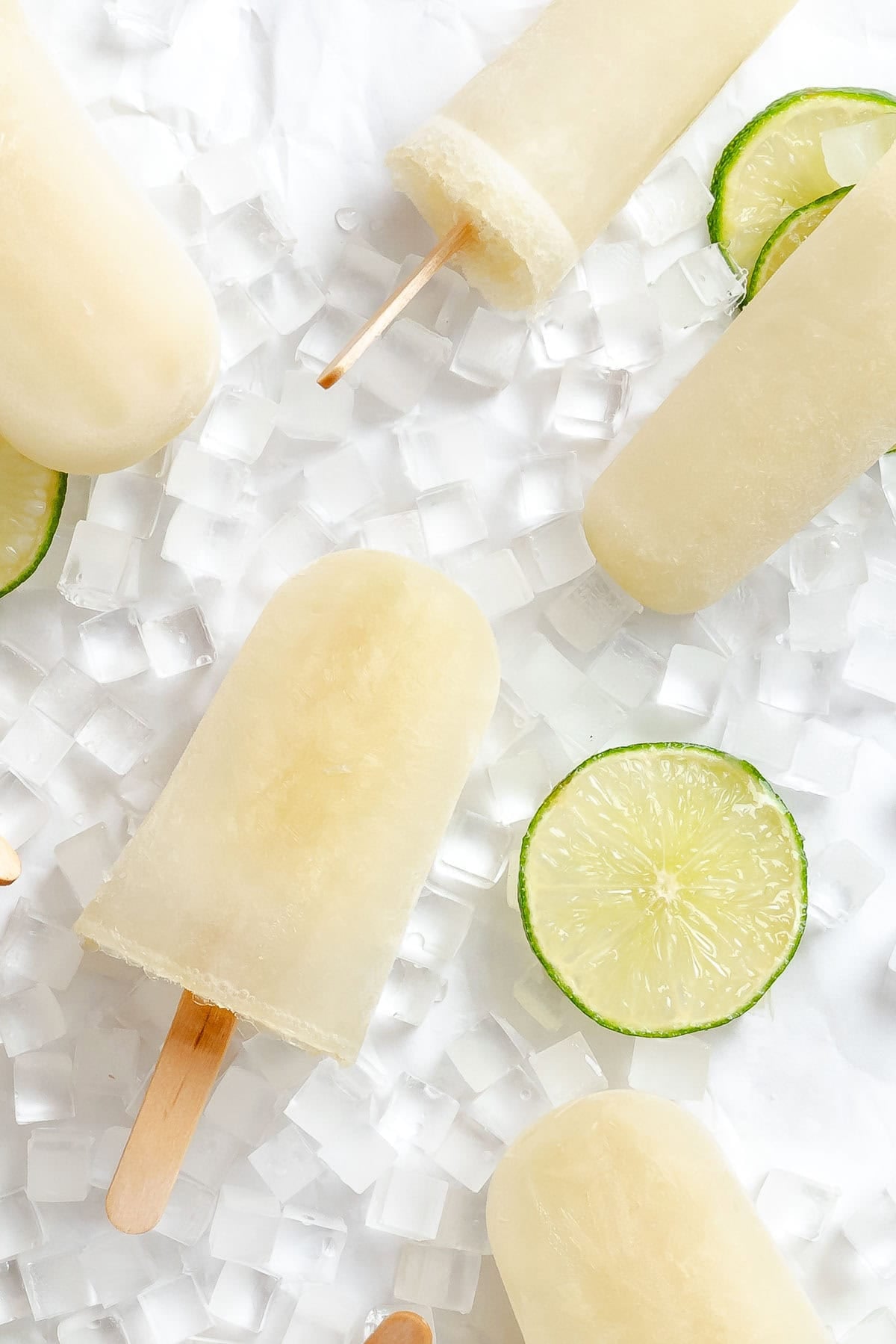 Several completed Easy Lime Popsicles on a white surface.