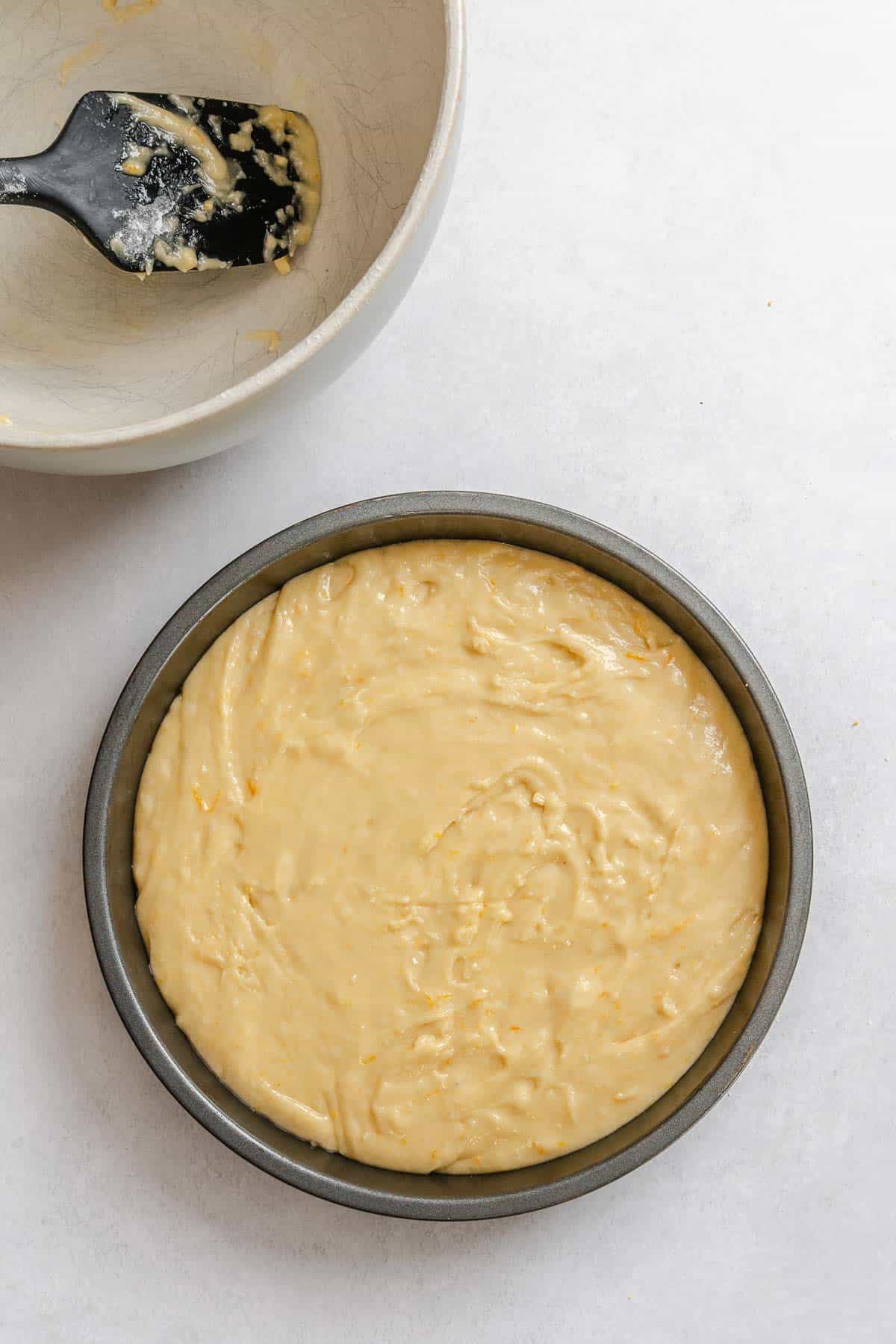 Process shot showing batter added to cake pan.