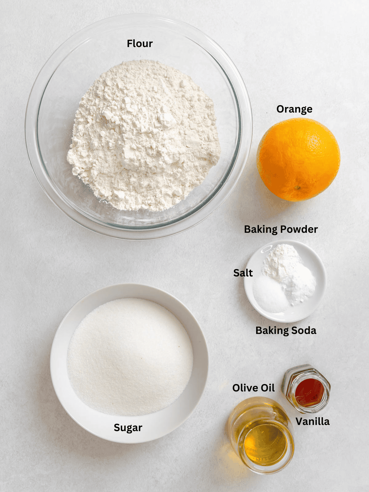 Ingredients for Orange Olive Oil Cake measured out on a white surface.
