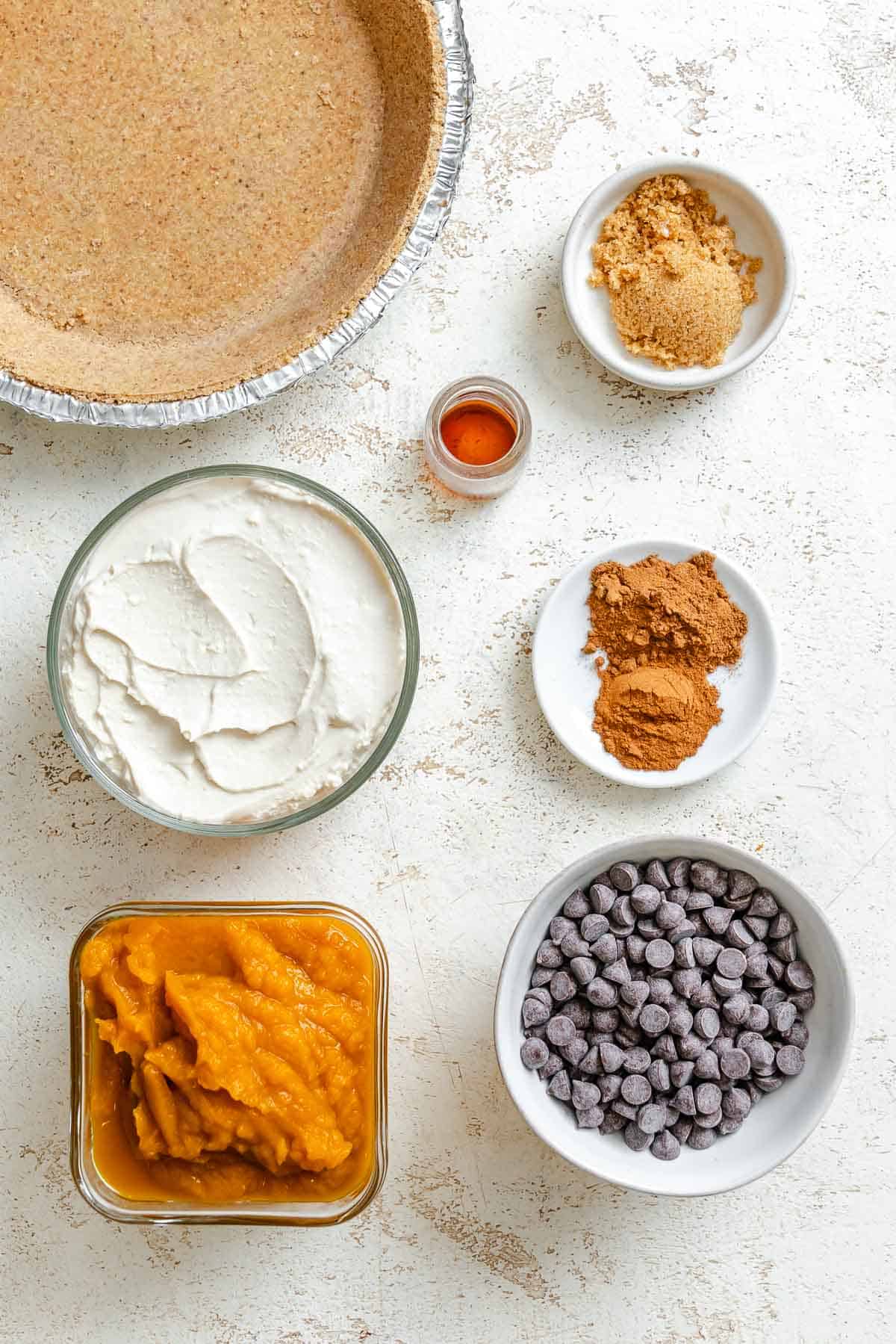 Ingredients for Chocolate Pumpkin Pie measured out on a white surface.