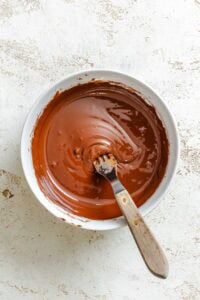 Melted vegan chocolate chips stirred smooth in a small bowl.