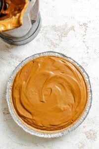 Chocolate pumpkin filling poured into a vegan pie crust.