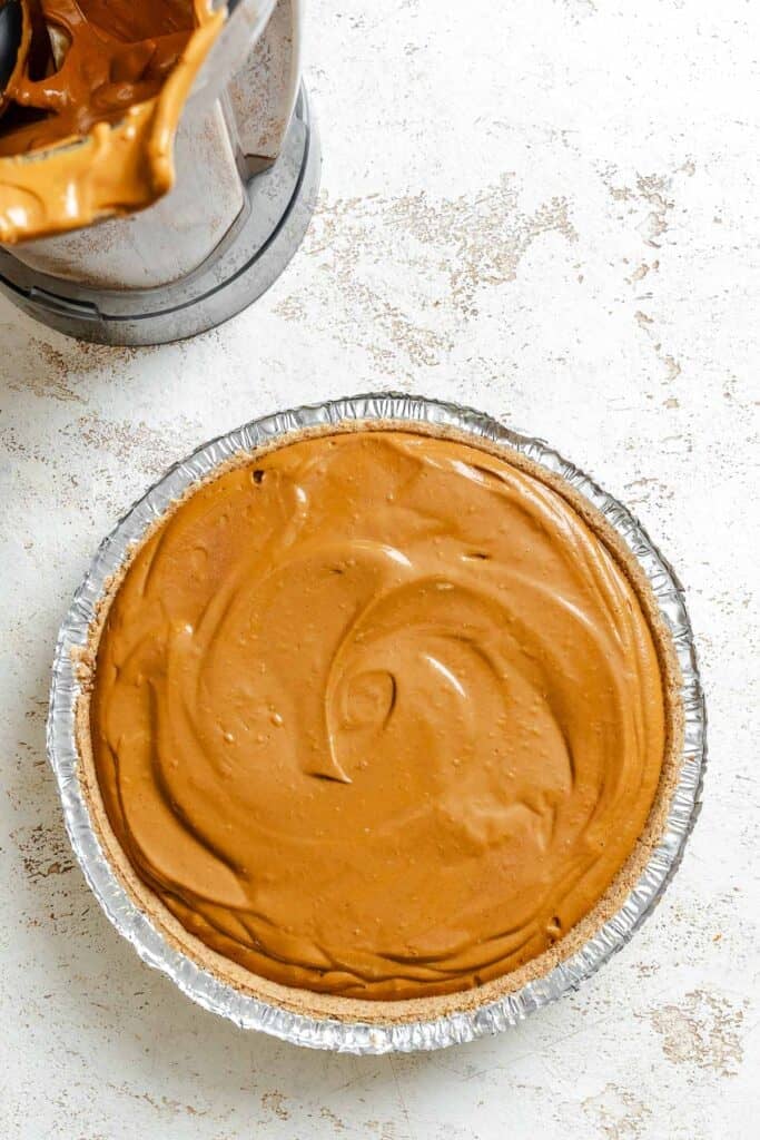 Process shot showing pie ingredients added to pie crust.