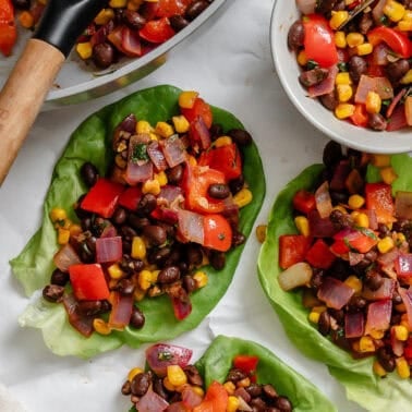 Several completed Vegetarian Lettuce Wraps (Beans & Corn) on a white surface.