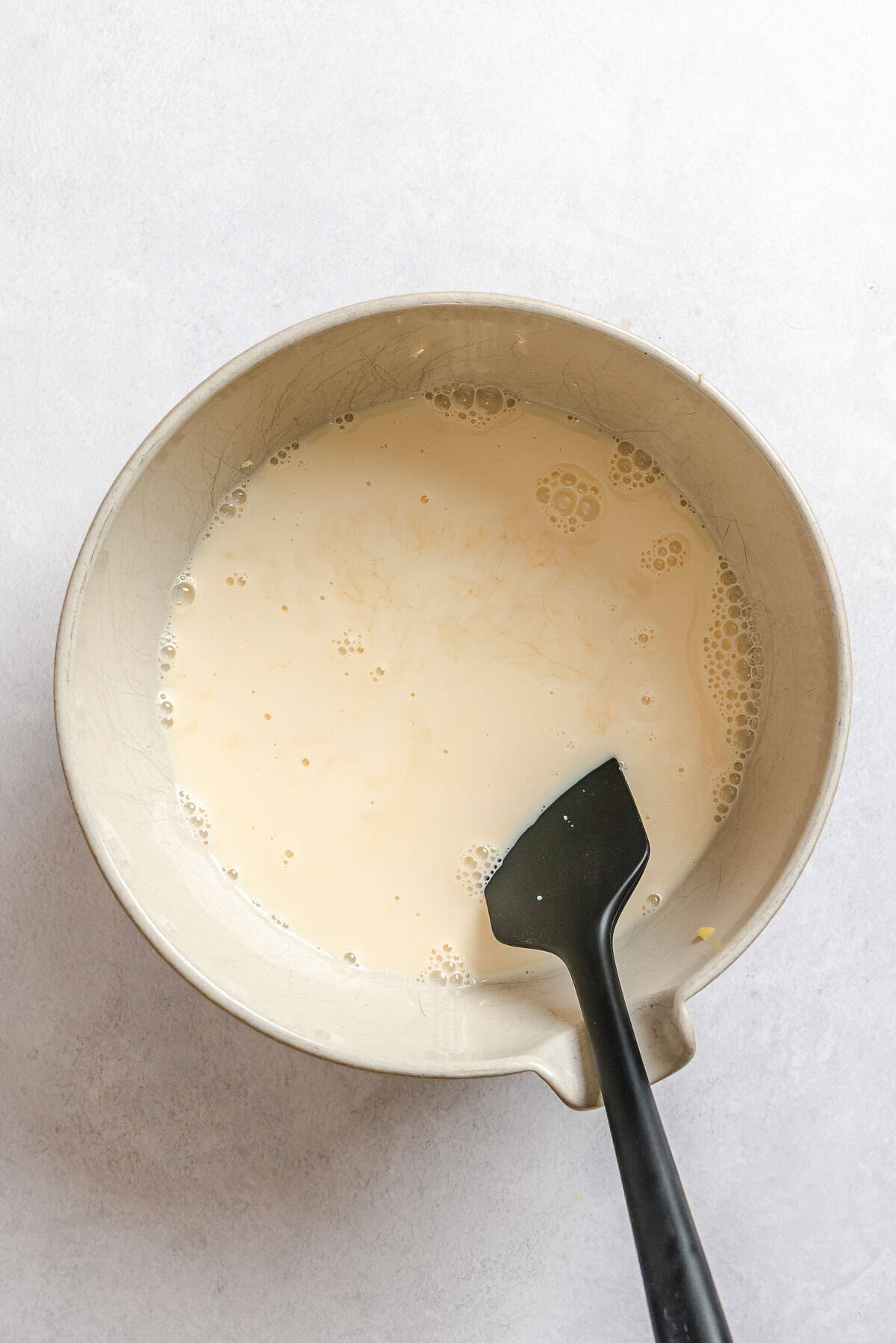 Process shot showing mixing ingredients in a bowl.