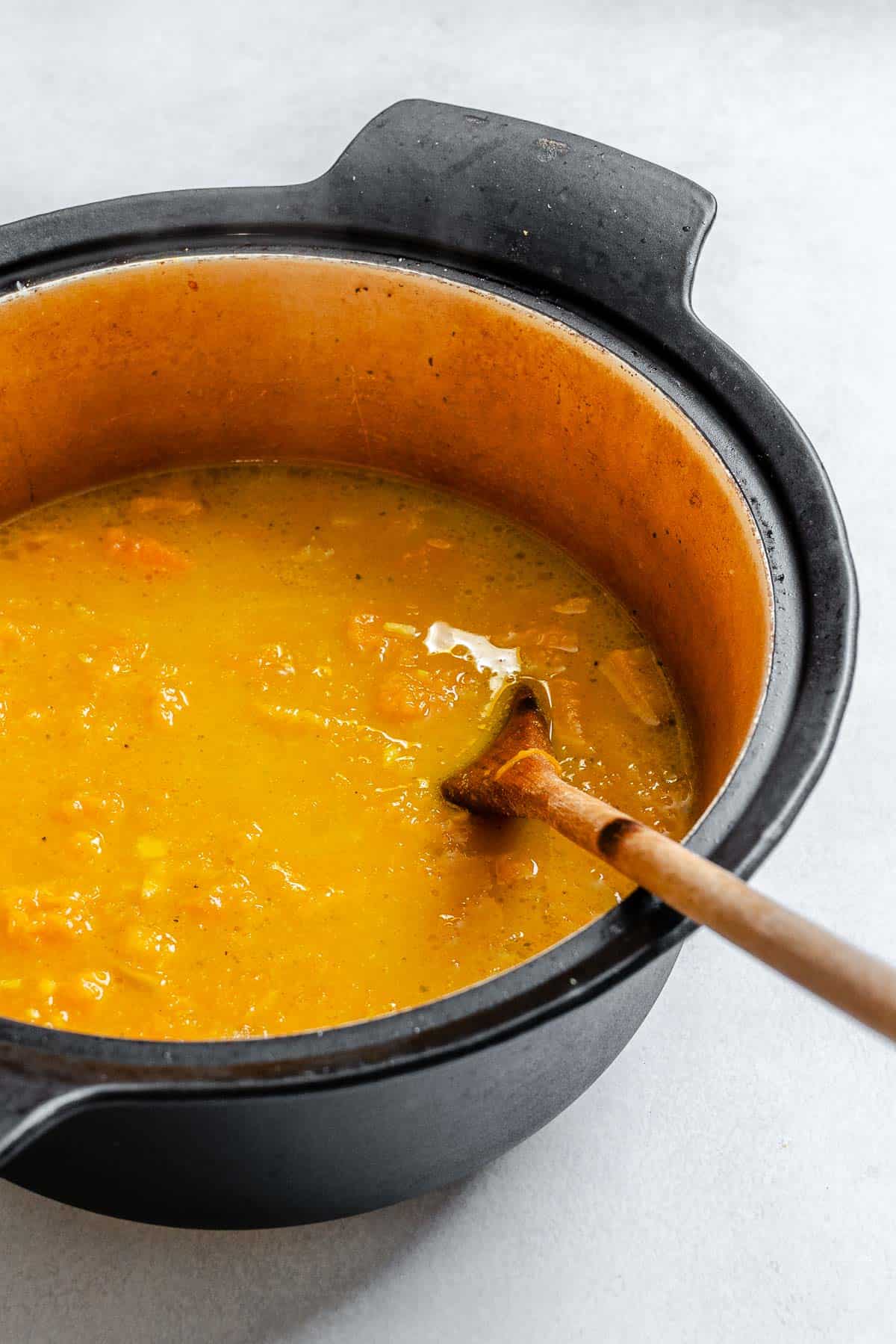 Process shot showing stirring ingredients in a pot.