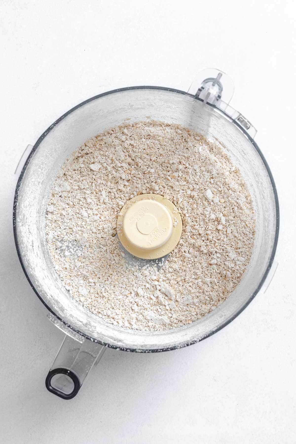 Process shot showing oats in a food processor.