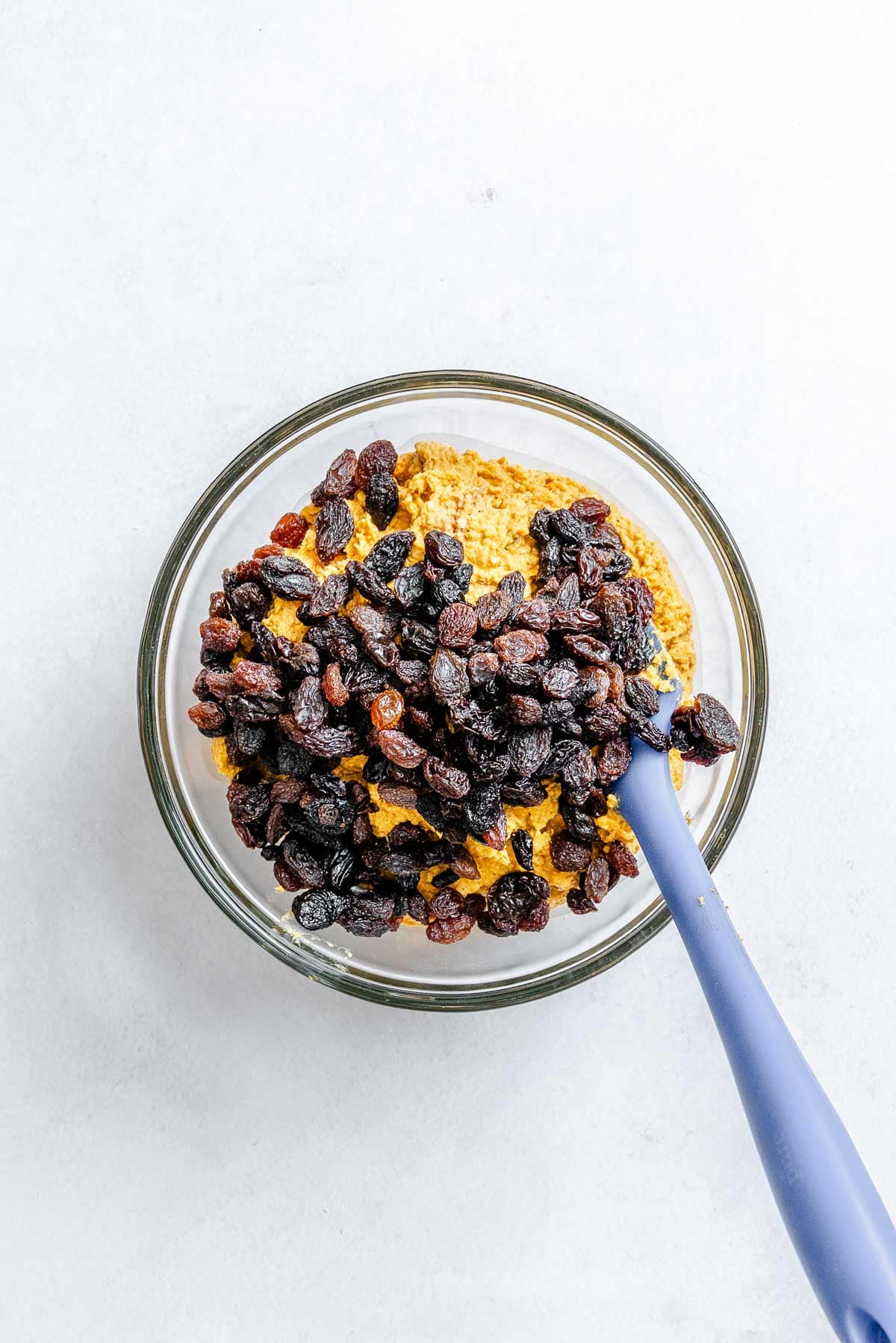 Process shot showing raisins added to food processor.