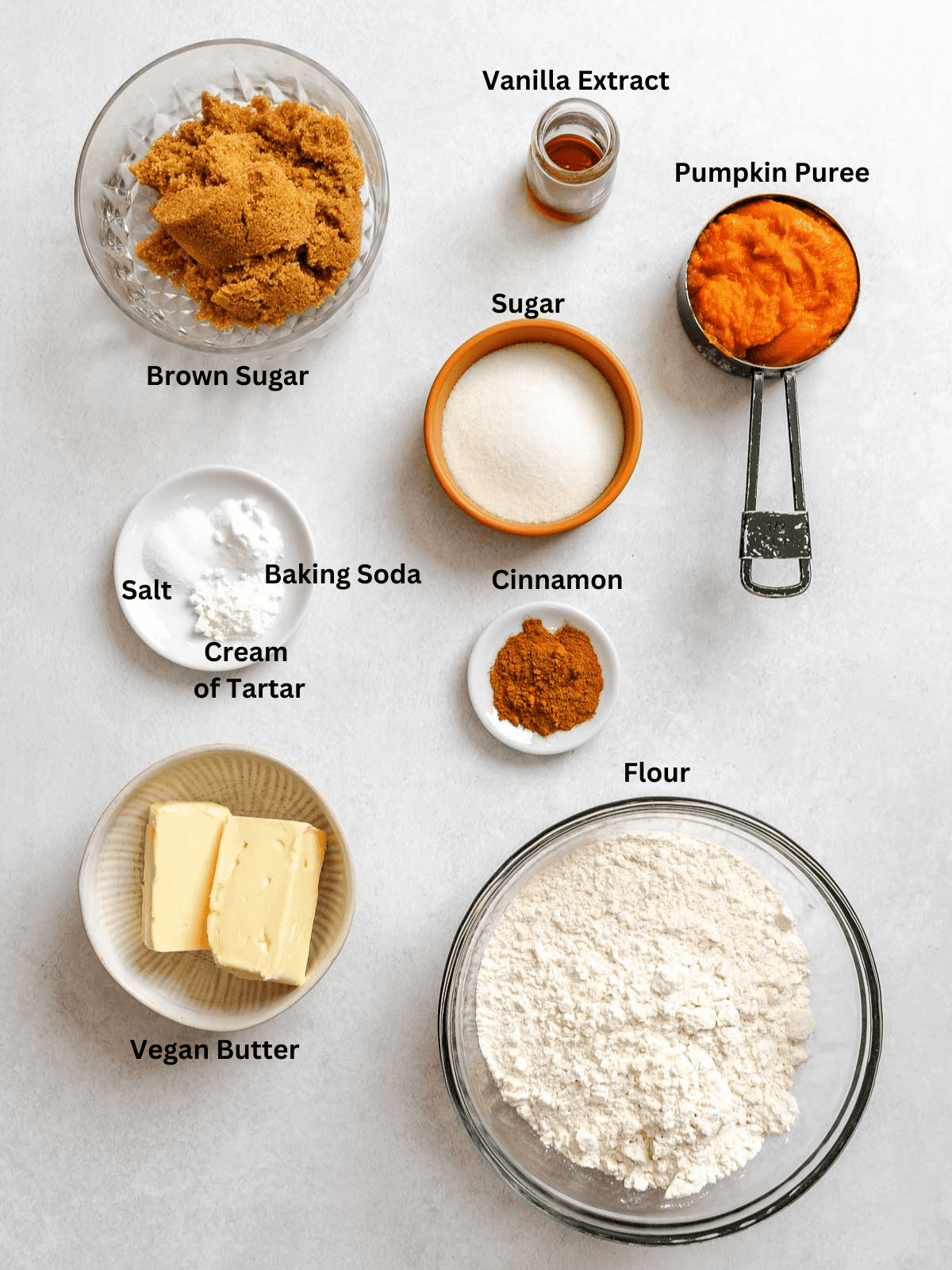 Ingredients for Pumpkin Snickerdoodles measured out on a white surface.