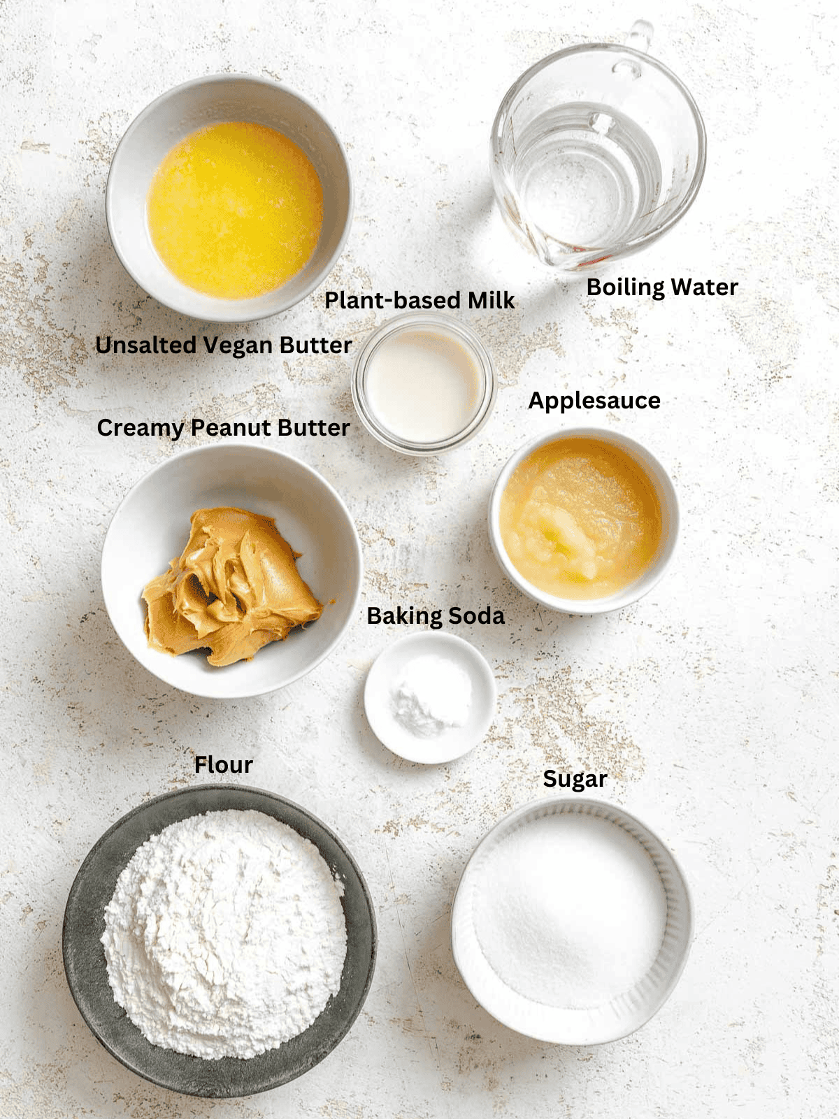 Ingredients for Vegan Peanut Butter Cake measured out on a white surface.