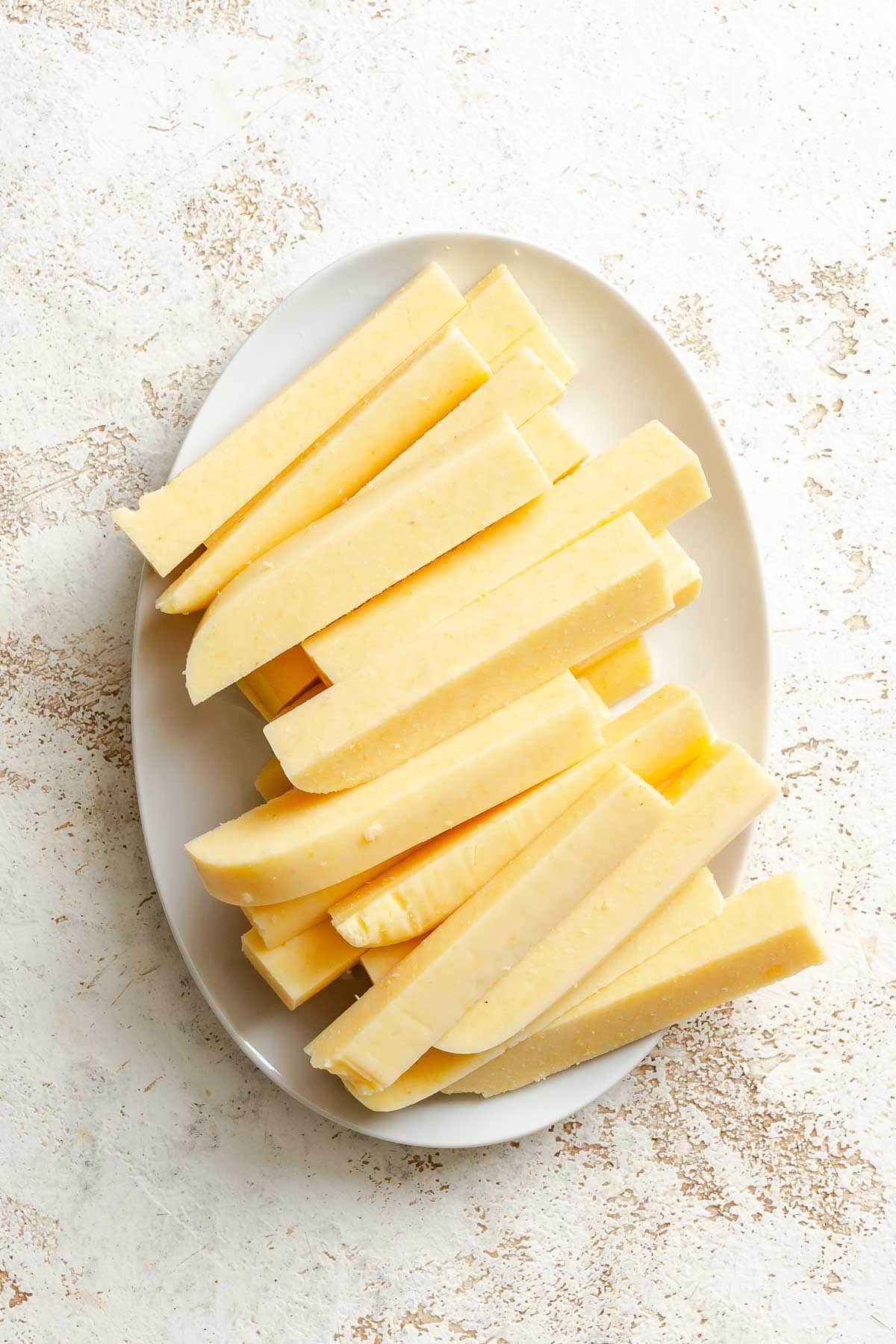 Process shot showing sliced polenta on a plate.