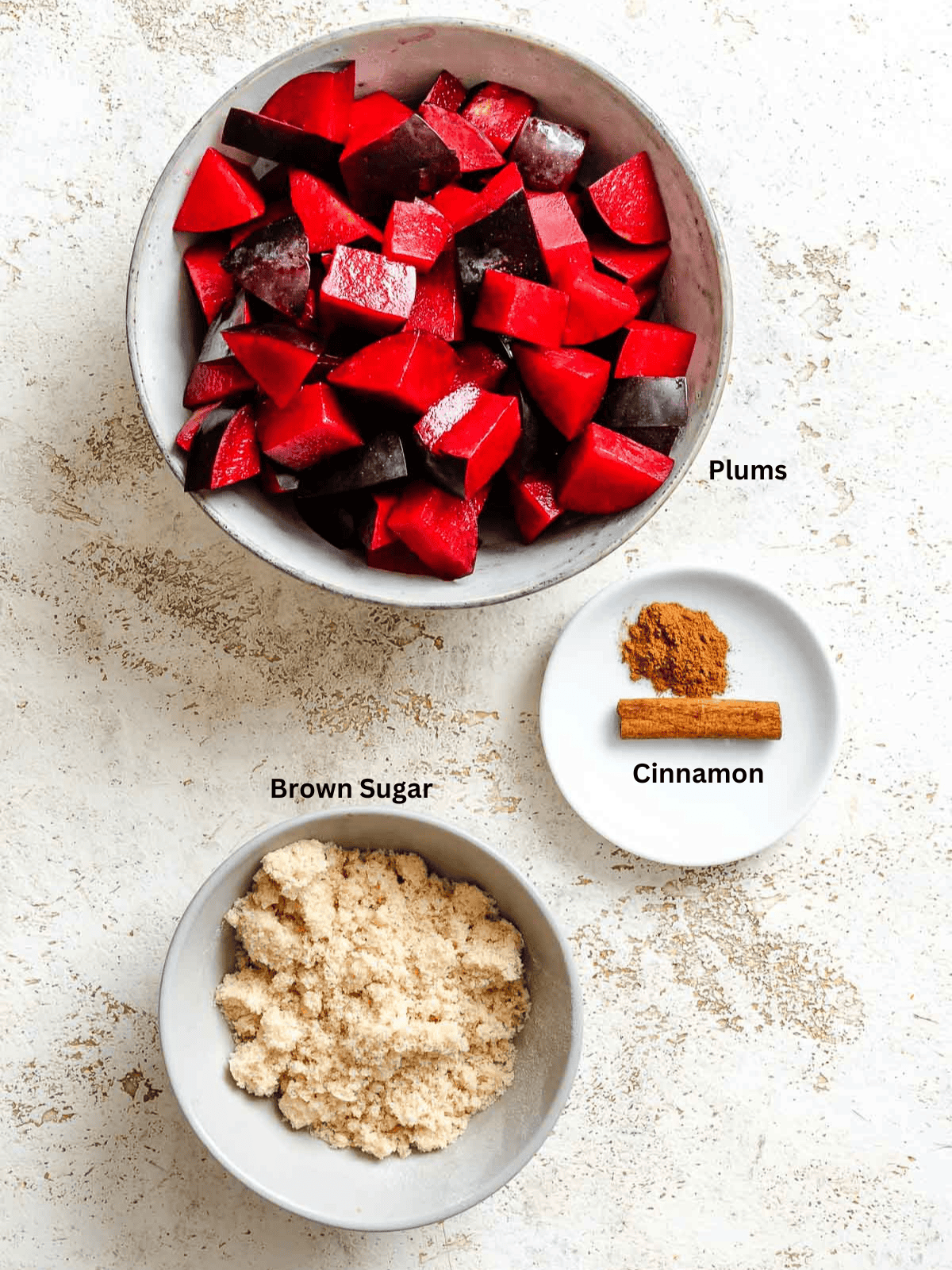 Ingredients for Easy Plum Jam (No Pectin) measured out on a white surface.