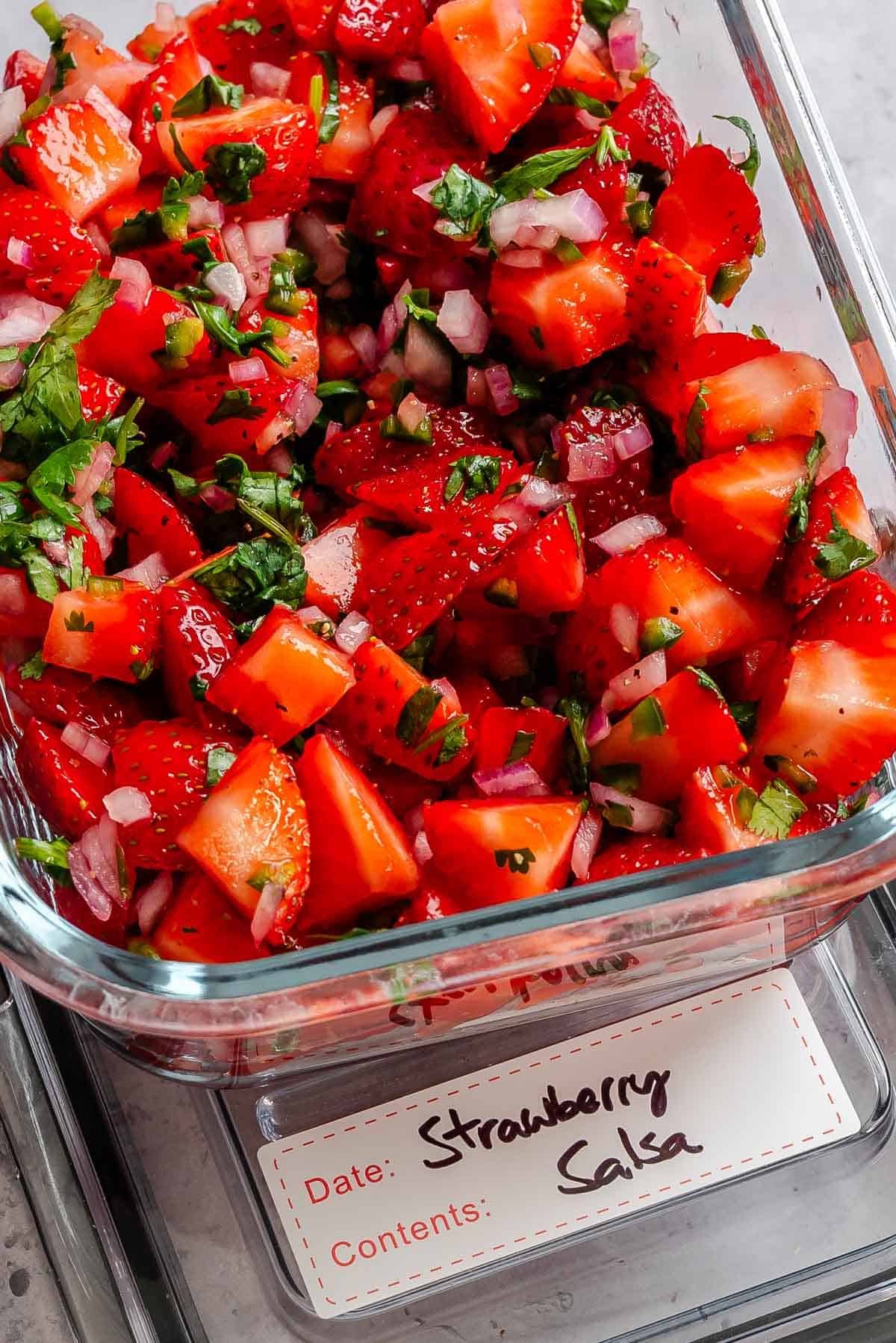 Completed strawberry salsa in a storage container.