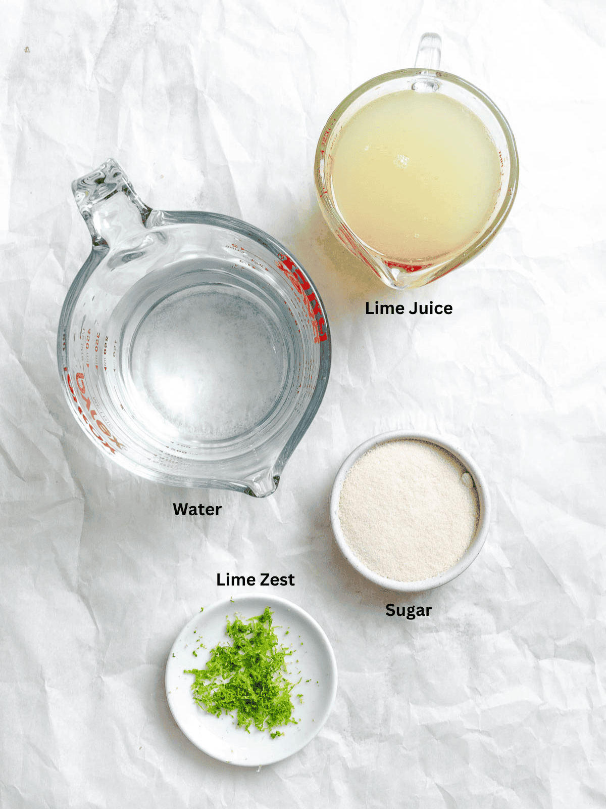 Ingredients for Easy Lime Popsicles measured out on a white surface.