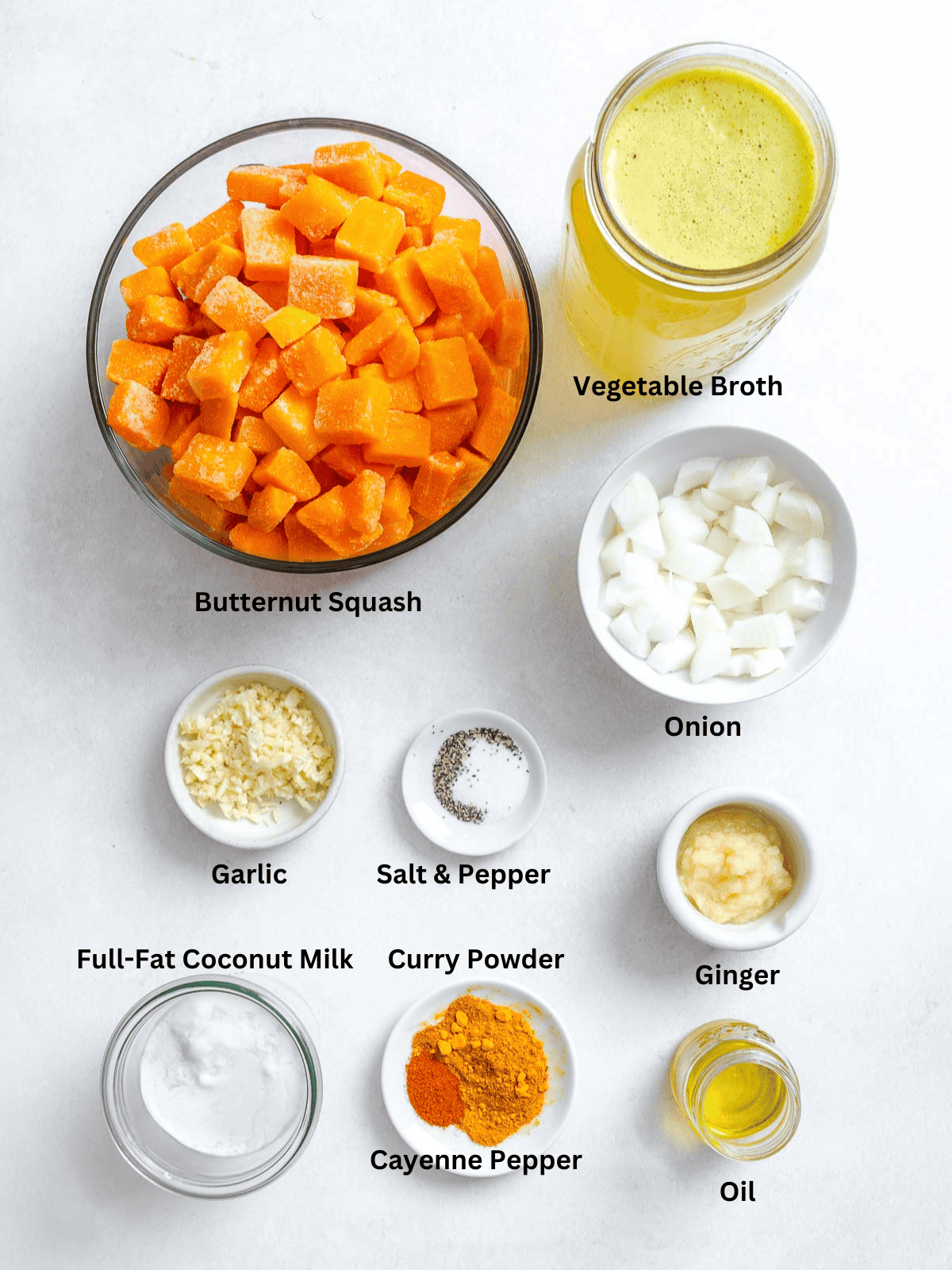 Ingredients for Curried Butternut Squash Soup measured out on a white surface.