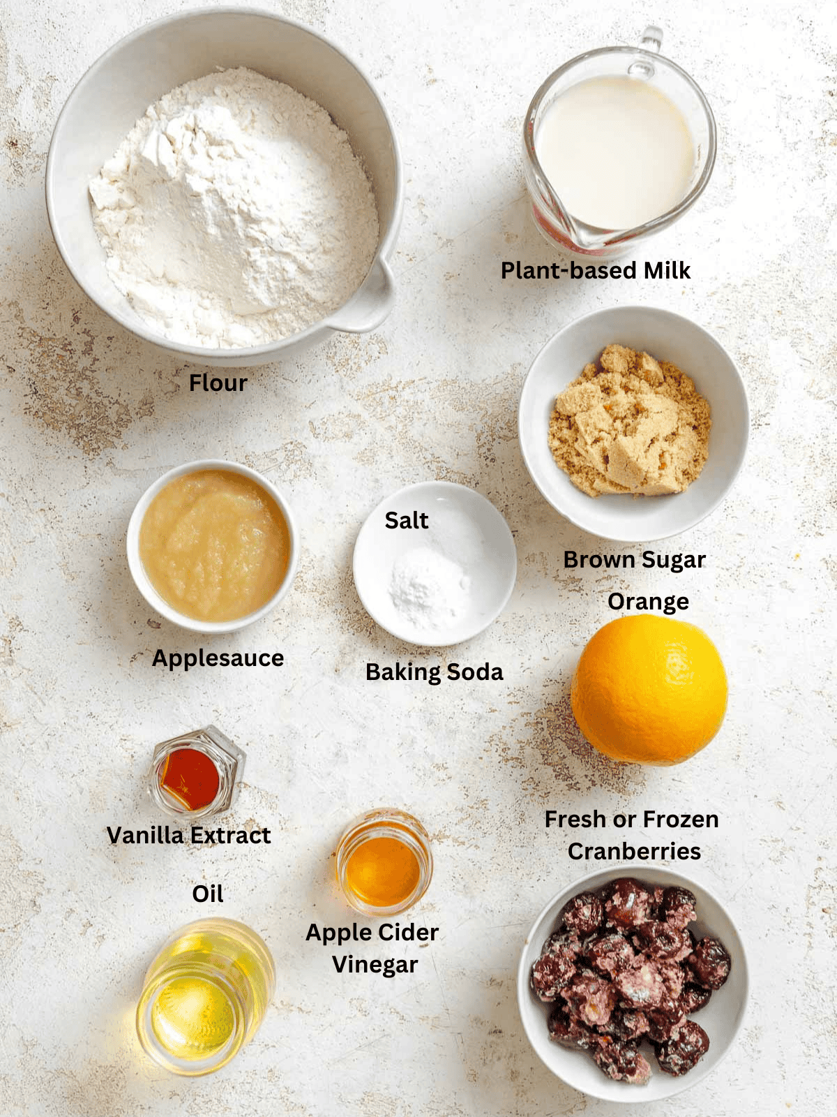 Ingredients for Cranberry Orange Bread (Eggless!) measured out on a white surface.