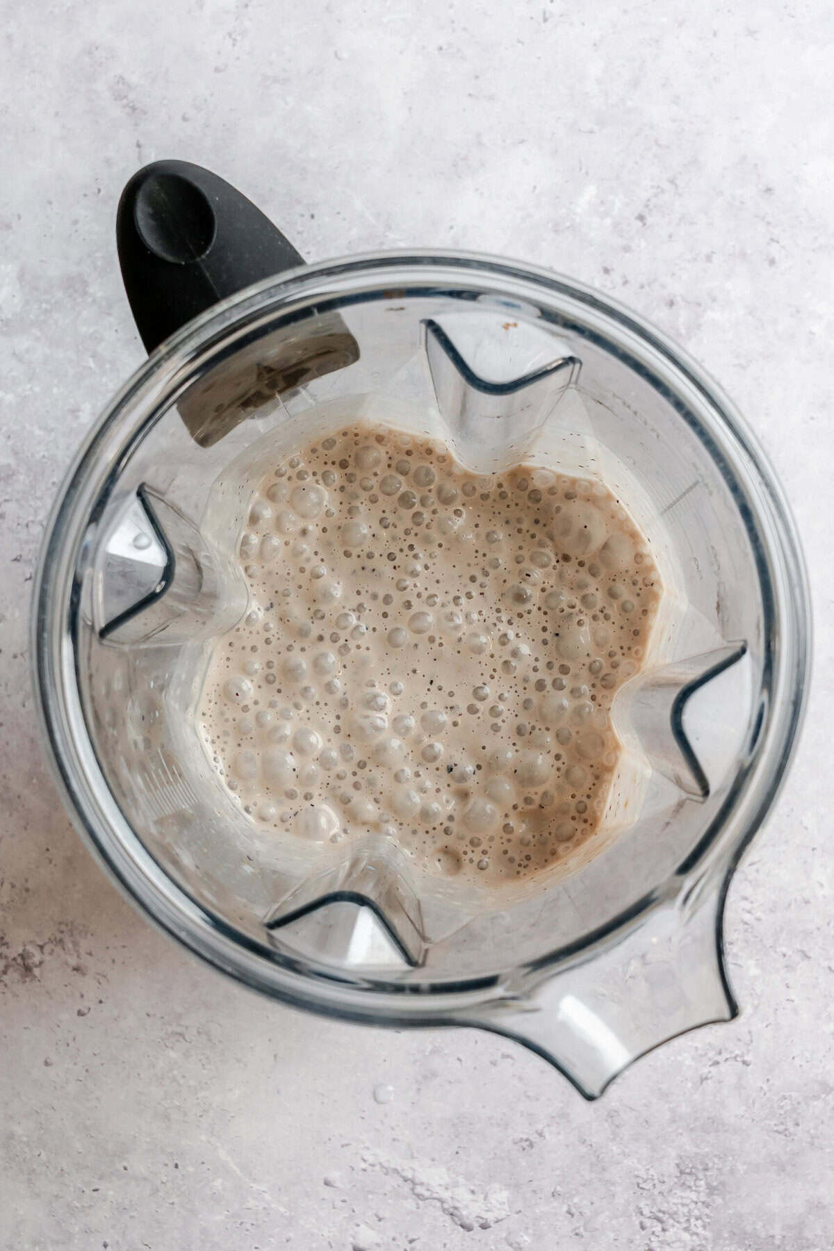 Process shot showing post blended smoothie in blender.