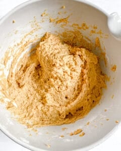 Thick vegan pumpkin bread batter mixed in a white bowl.